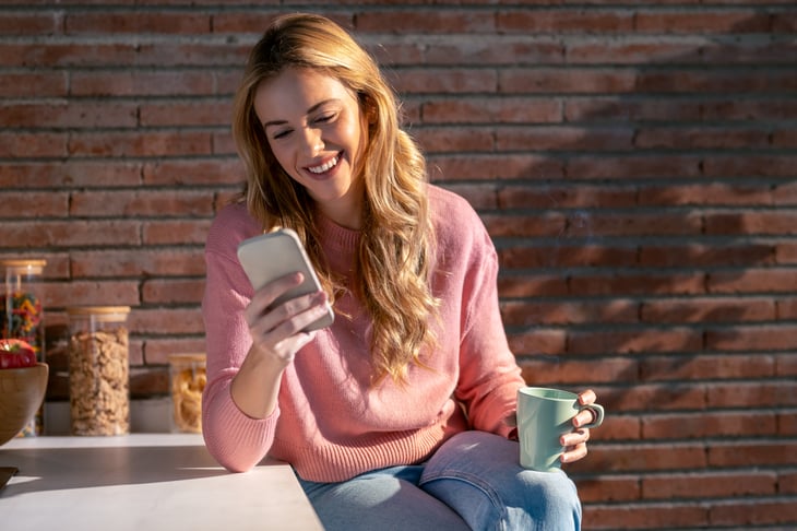 female-european-adult-outdoor-smiling-and-using-her-mobile-phone-web-2