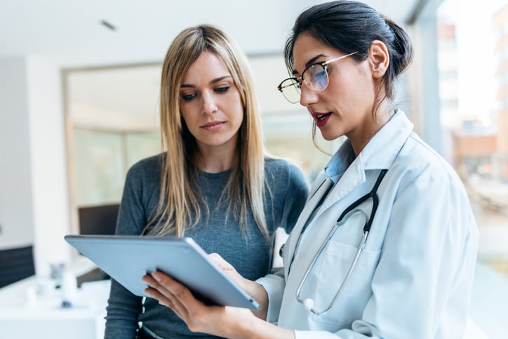 female-european-adult-patients-clinic-looking-tablet-of-doctor-web