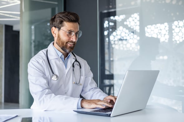 male-european-adult-doctor-clinic-working-on-laptop-print