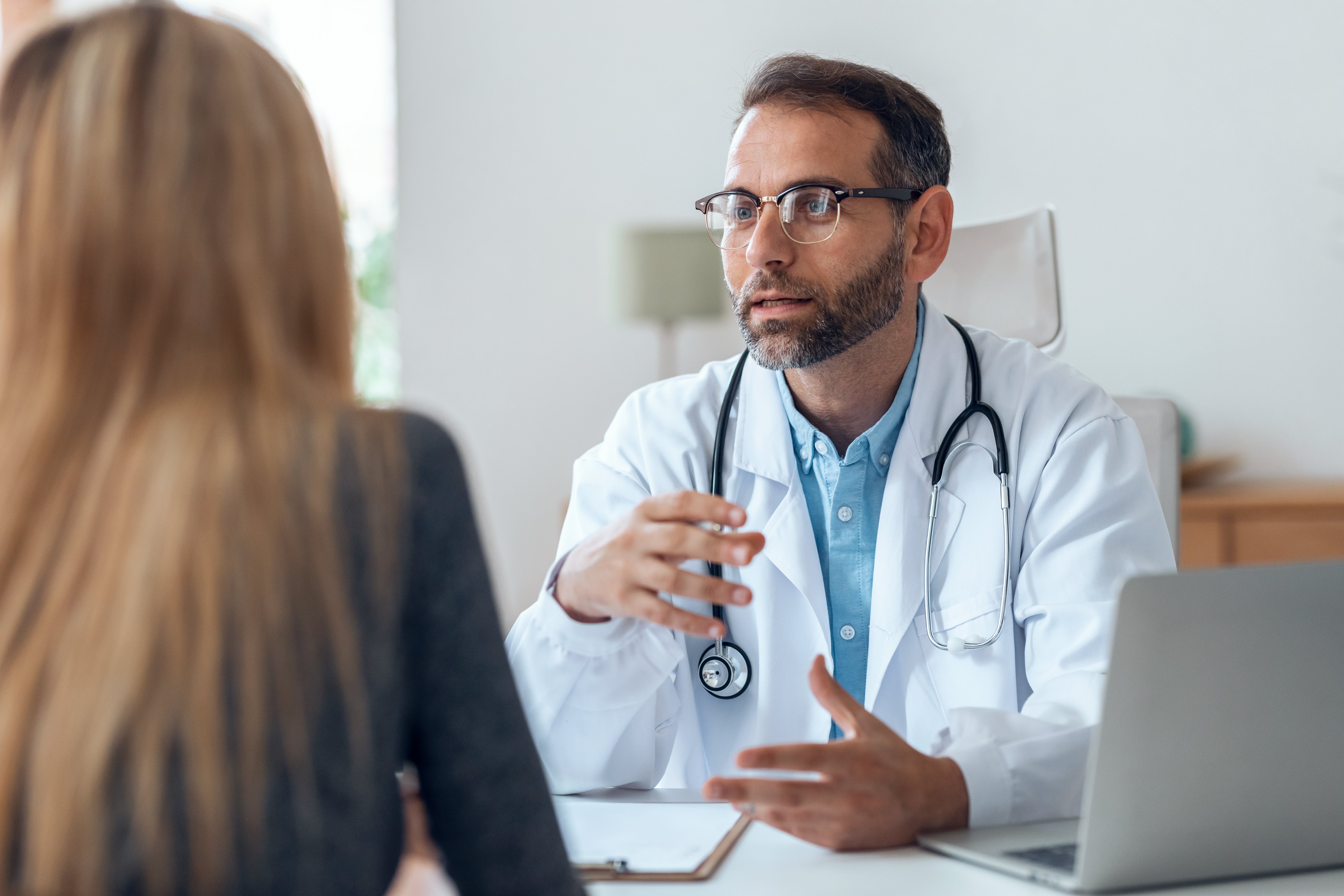 male-european-adult-doctor-consultation-room-giving-advice-to-his-patient-print-2